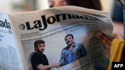 A woman reads La Jornada newspaper in Mexico City, on January 10, 2016 which shows a picture of drug lord Joaquin Guzman, aka "El Chapo" (R), shaking hands with US actor Sean Penn. 