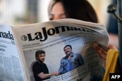 A woman reads La Jornada newspaper in Mexico City, on January 10, 2016 which shows a picture of drug lord Joaquin Guzman, aka "El Chapo" (R), shaking hands with US actor Sean Penn.