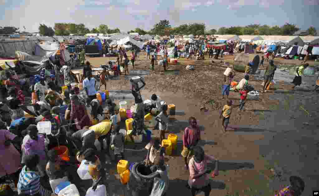 Displaced people gather around a water truck to fill containers at a United Nations compound in the capital, Juba, that has become home to thousands of people displaced by fighting.