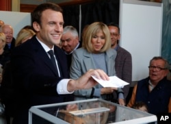 Centrist presidential election candidate Emmanuel Macron, left, prepares to vote, alongside his wife Brigitte, in the first round of France's presidential election in Le Touquet, northern France, April 23, 2017.