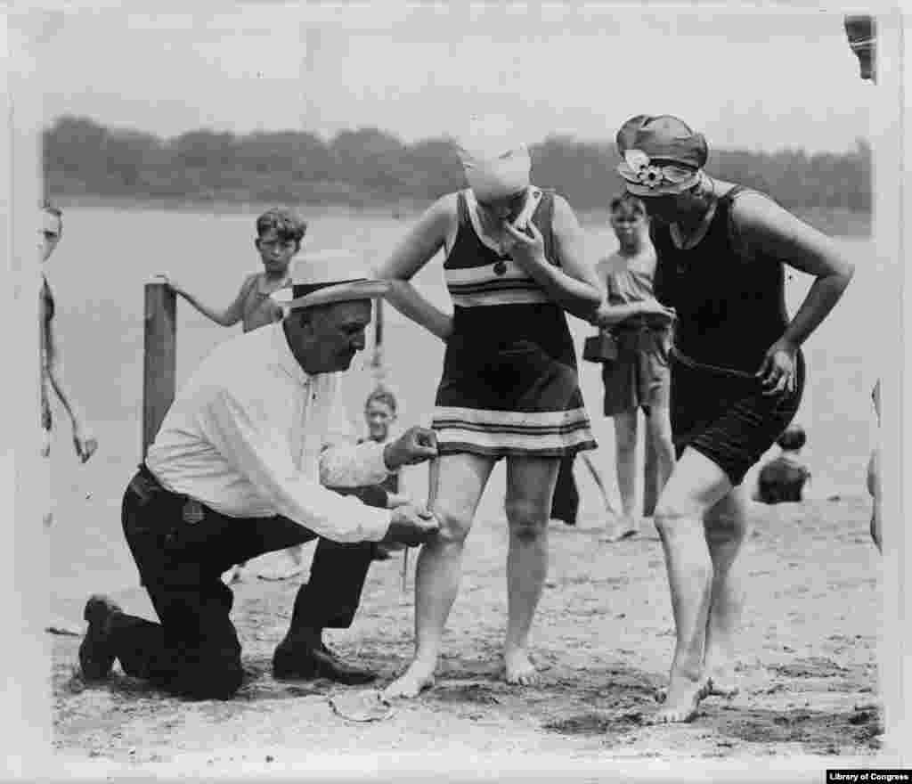 Bill Norton, the bathing beach &quot;cop&quot;, using a tape measure to determine the distance between a woman&#39;s knee and the bottom of her bathing suit on a beach in Washington, D.C. 