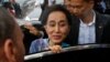 FILE - Myanmar State Counselor Aung San Suu Kyi leaves a meeting with migrant workers at the coastal fishery center of Samut Sakhon, Thailand, June 23, 2016. 