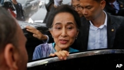 FILE - Myanmar State Counselor Aung San Suu Kyi leaves a meeting with migrant workers at the coastal fishery center of Samut Sakhon, Thailand, June 23, 2016. 