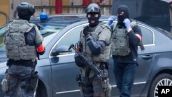 Cảnh sát trong đội đặc nhiệm của Bỉ bảo vệ khu vực vụ đột kích ở khu vực Molenbeek ở thủ đô Brussels, Bỉ, hôm 18/3.