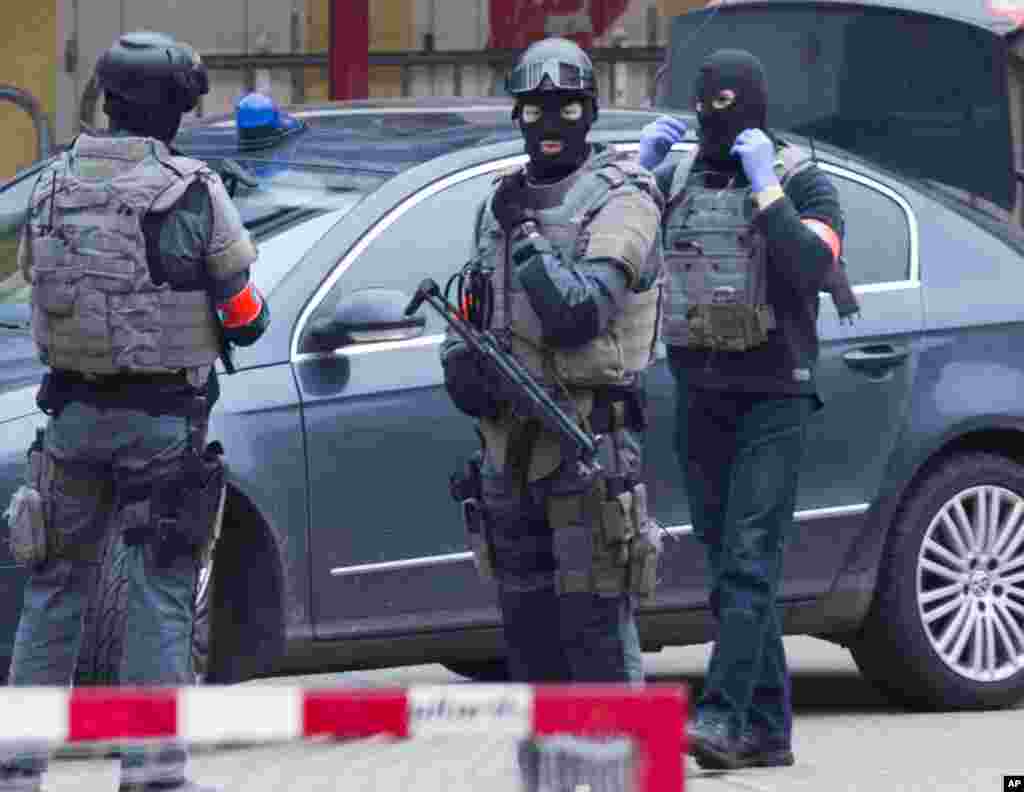 Polisi wa kikosi maalum wakilinda eneo ambalo polisi wanashambulia katika kiunga cha Brussel cha Molenbeek, Machi 18, 2016.