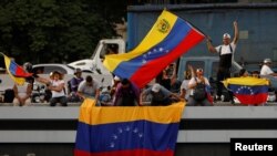 Partidarios del candidato presidencial opositor venezolano Edmundo González ondean banderas de Venezuela antes de su mitin de cierre de campaña, en Caracas, Venezuela, el 25 de julio de 2024. [Foto: Reuters]