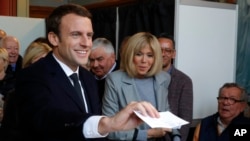 Kandidat presiden dari sayap tengah, Emmanuel Macron, kiri, bersiap untuk memberikan suaranya, bersama dengan sang istri, Brigitte, dalam putara pertama pilpres Perancis di Le Touquet, Perancis bagian utara, 23 April 2017. (foto: Philippe Wojazer, Pool photo via AP)