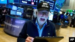 Trader Peter Tuchman wears a "Dow $35,000" hat to mark the Dow Jones Industrial Average closing at 35,061.55, on the floor of the New York Stock Exchange, July 23, 2021, in New York. 