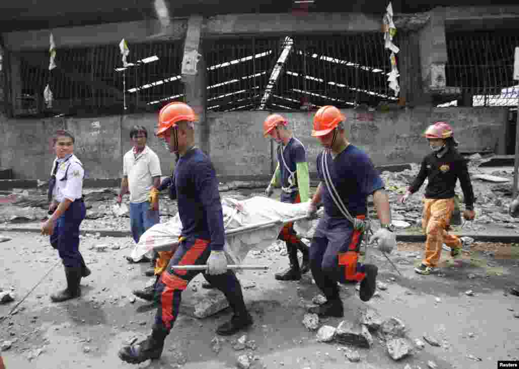 Rescue members recover the body of a vendor killed after an earthquake hit Pasil market in Cebu, central Philippines, Oct. 15, 2013.
