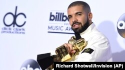 Drake poses in the press room with his 13 awards at the Billboard Music Awards.