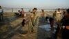 FILE - A snake charmer walks with pythons on his shoulder to attract tourists in Amarapura, Mandalay region, Myanmar, Jan. 2, 2016. Mandalay alone registers an estimated 700 to 800 snake bite victims each year.