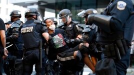 A demonstrator is taken into custody by police after a curfew took effect during a protest over the death of George Floyd, Monday, June 1, 2020, near the White House in Washington.