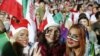 FILE -- Iranian women cheer as they wave their country's flag after authorities in a rare move allowed a select female group into Tehran's Azadi Stadium to watch a friendly soccer match between Iran and Bolivia, Oct. 16, 2018. 