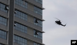 A Sri Lankan airforce helicopter flies over a house suspected to be a hideout of militants following a shoot out in Colombo, Sri Lanka, Sunday, April 21, 2019.