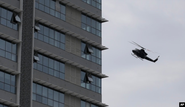 A Sri Lankan airforce helicopter flies over a house suspected to be a hideout of militants following a shoot out in Colombo, Sri Lanka, Sunday, April 21, 2019.