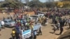 Members of ZANU-PF party march in Harare chanting songs to show support for first lady Grace Mugabe. They hold placards saying “Gabriella Engels is not an angel.”