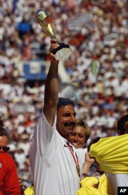 FILE - U.S. women's soccer team head coach Tony DiCicco celebrates by holding the trophy aloft after defeating China in the Women's World Cup Final at the Rose Bowl in Pasadena, Calif., July 10, 1999.