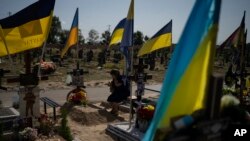 Una mujer llora ante la tumba de su hijo que murió luchando en la guerra, mientras los ucranianos celebran el Día de la Independencia en Kharkiv, Ucrania, el jueves 24 de agosto de 2023.