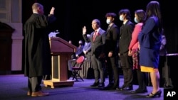Sokhary Chau (49 tahun) didampingi anggota keluarganya, saat diambil sumpah jabatan oleh Hakim Stephen Geary (kiri) sebagai Walikota Lowell negara bagian Massachusetts, Senin (3/1). 