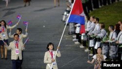 Cambodia's flagbearer Davin Sorn holds the national flag as she leads the contingent in the athletes parade during the opening ceremony of the London 2012 Olympic Games at the Olympic Stadium July 27, 2012. 