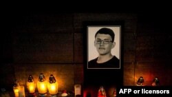 Candles and a portrait of Slovak investigative journalist Jan Kuciak