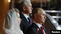 Russian President Vladimir Putin (R), Moscow Mayor Sergei Sobyanin and Prime Minister Dmitry Medvedev's wife Svetlana (L) attend an Orthodox Easter service in Moscow April 20, 2014.