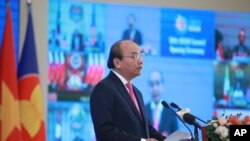 El primer ministro vietnamita, Nguyen Xuan Phuc, pronuncia un discurso frente a una pantalla de televisión que muestra a los líderes de la ASEAN en la ceremonia de apertura de la 36ª Cumbre de la ASEAN en Hanoi, Vietnam, el viernes.