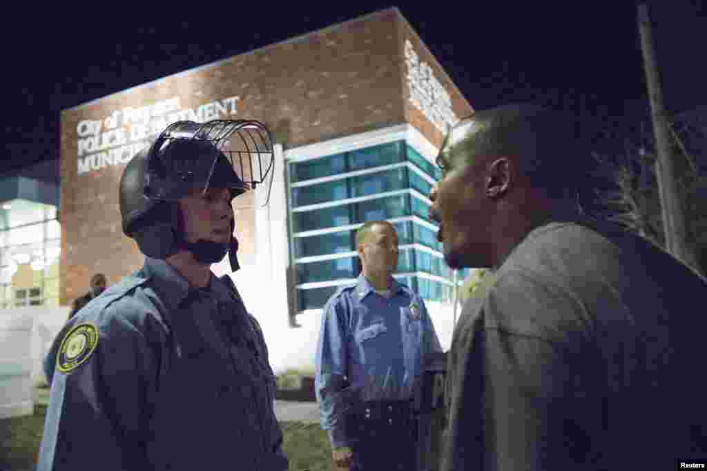 A protester confronts a police officer outside the City of Ferguson Police Department and Municipal Court in Ferguson, Mo., March 11, 2015.