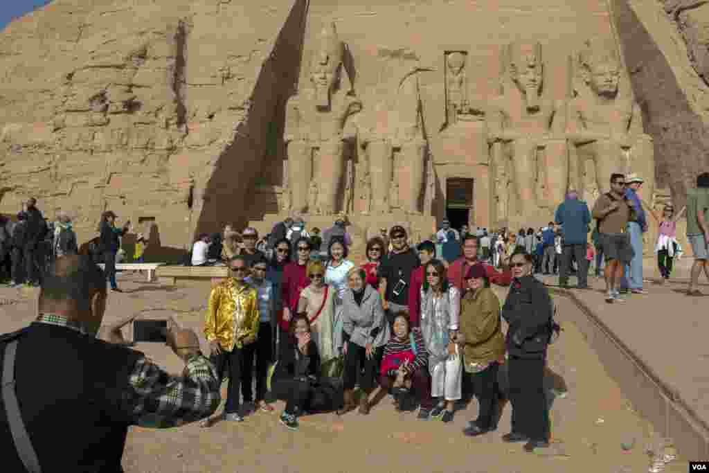 Para wisatawan berpose ketika berfoto di kuil Abu Simble di Aswan, selatan Mesir, setelah di festival matahari selesai pada 22 Februari 2018.&nbsp; (H. Elrasam/VOA)