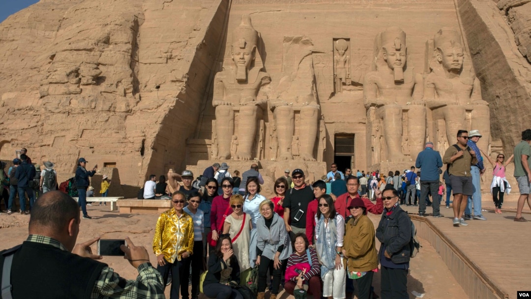 Tourists pose for a group portrait at Abu Simbel temple in Aswan, southern Egypt, after the rituals of the sun festival ended, Feb. 22, 2018. (H. Elrasam/VOA)
