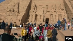 Tourists pose for a group portrait at Abu Simbel temple in Aswan, southern Egypt, after the rituals of the sun festival ended, Feb. 22, 2018. (H. Elrasam/VOA)
