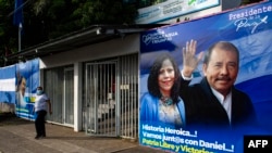 Una mujer pasa junto a una pancarta que promueve la candidatura del presidente de Nicaragua, Daniel Ortega, y su esposa y compañera de fórmula Rosario Murillo, en Managua el 24 de septiembre de 2021.