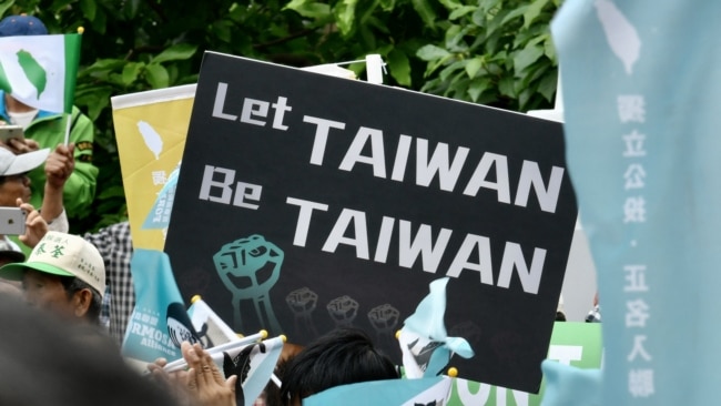 FILE - A demonstrator holds a placard in support of Taiwan during a rally ahead of an identity referendum in Taipei, October 20, 2018.