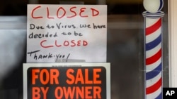 Tulisan "Dijual Tanpa Perantara" dan "Ditutup karena Virus" tampak di jendela toko Images On Mack di Grosse Pointe Woods, Michigan, 2 April 2020.