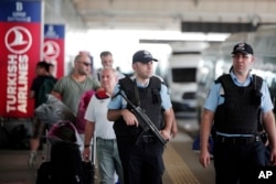 Turkish police officers patrol outside Istanbul's Ataturk airport, June 29, 2016. A day after suicide bombers killed scores of people at the airport, Turkey's prime minister has named the Islamic State group as the chief suspect behind the attack.