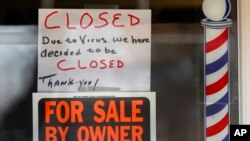 美国密西根州一家理发店门前打出“受新冠病毒影响本店关门”的告示（2020年4月2日）。新冠病毒疫情已经导致美国1000多万人失业。