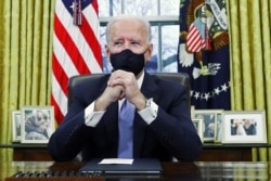 President Joe Biden gets set to sign executive orders in the Oval Office of the White House in Washington, after his inauguration as the 46th U.S. president, Jan. 20, 2021.