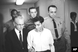 FILE - Sirhan Sirhan is escorted by his attorney, Russell E. Parsons, from Los Angeles County Jail's chapel to enter a plea to a charge of murder in Los Angeles, in the fatal shooting of Sen. Robert F. Kennedy, June 28, 1968.