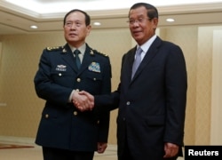 2018年6月18日中国国防部长魏凤和（左）在柬埔寨金边会晤柬埔寨首相洪森。魏凤和6月16日抵达柬埔寨，出席在金边举办的中柬军事展览。路透社报道，柬埔寨国防部发言人索切特表示，中国承诺提供超过一亿美元的援助，柬埔寨可自行决定如何使用。这位发言人表示，与中国的合作为柬埔寨提供了数百辆军事运输车，柬埔寨指挥人员乘坐的汽车以及联合军演所需费用。另外，两国明年将再度举行“金龙”联合军演。
