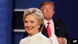 FILE - Democratic presidential nominee Hillary Clinton walks off stage as Republican presidential nominee Donald Trump puts his notes away after the third presidential debate at UNLV in Las Vegas, Oct. 19, 2016.