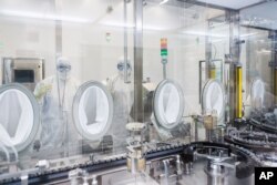 Lab technicians fill vials of investigational coronavirus disease (COVID-19) treatment drug remdesivir at a Gilead Sciences facility in La Verne, California, U.S. March 18, 2020.