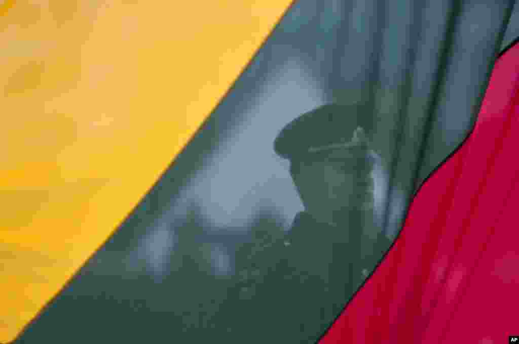A Lithuanian soldier is seen behind a national flag being raised, during a celebration of the country&#39;s declaration of independence in Vilnius. Lithuania celebrated its 26th anniversary of independence from the Soviet Union, recalling seminal events that set the Baltic nation on a path to freedom and helped lead to the collapse of the U.S.S.R.