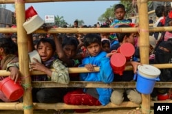 Rohingya refugees wait for food aid at Thankhali refugee camp in Bangladesh's Ukhia district on January 12, 2018.