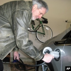 Volt owner Jeff Parmet disconnects the power cord from his new electric car.