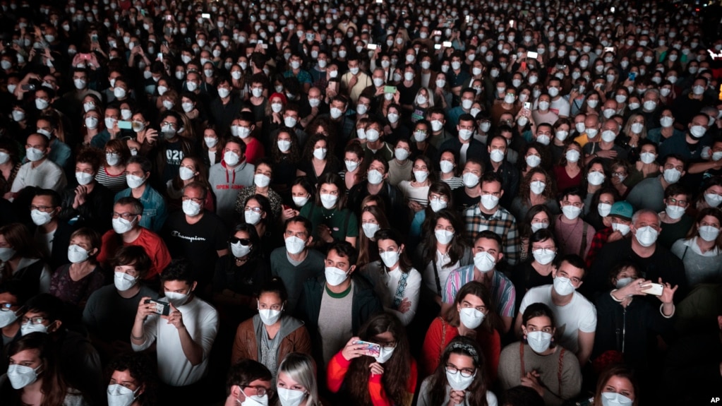 FILE - People using face masks attend a music concert in Barcelona, Spain, March 27, 2021. (AP Photo/Emilio Morenatti, File)