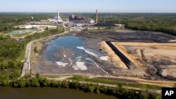 FILE -The Richmond city skyline can be seen on the horizon behind the coal ash ponds along the James River near Dominion Energy's Chesterfield Power Station in Chester, Va., May 1, 2018.