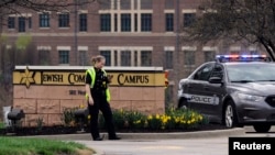 Polisi menjaga pintu masuk tempat penembakan di Pusat Komunitas Yahudi di Overland Park, Kansas (13/4). 