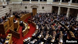 FILE - Greek Prime Minister Alexis Tsipras addresses lawmakers during a parliamentary session in Athens, Greece, Jan. 16, 2019. 