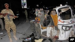 FILE - A Somali soldier stands guard near a destroyed auto rickshaw after a car bomb was detonated in Mogadishu, Somalia, Aug 4, 2017. At least three people were killed in the blast. On Aug. 10, another car bomb blast injured three people in the city.