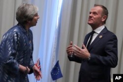 FILE - European Union Council President Donald Tusk (R) speaks with British Prime Minister Theresa May during a bilateral meeting on the sidelines of a summit of EU and Arab leaders at the Sharm El Sheikh, Egypt, Feb. 24, 2019.